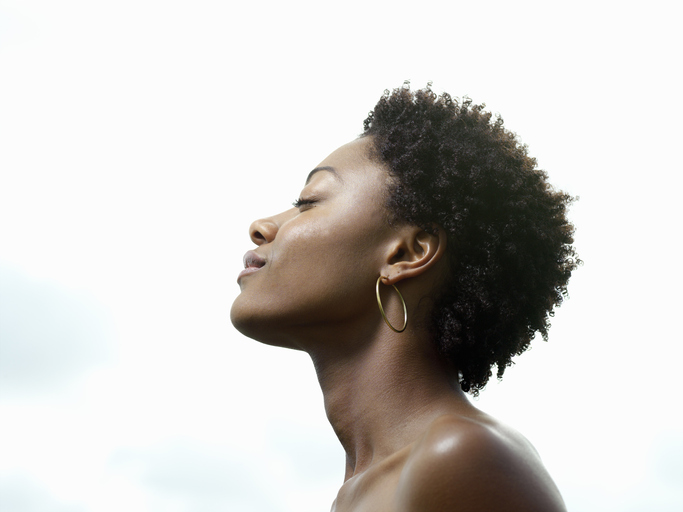 Young woman, eyes closed, low angle view, profile