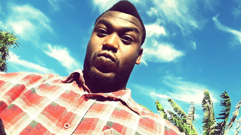 Portrait Of Young Man Puckering Lips Against Blue Sky