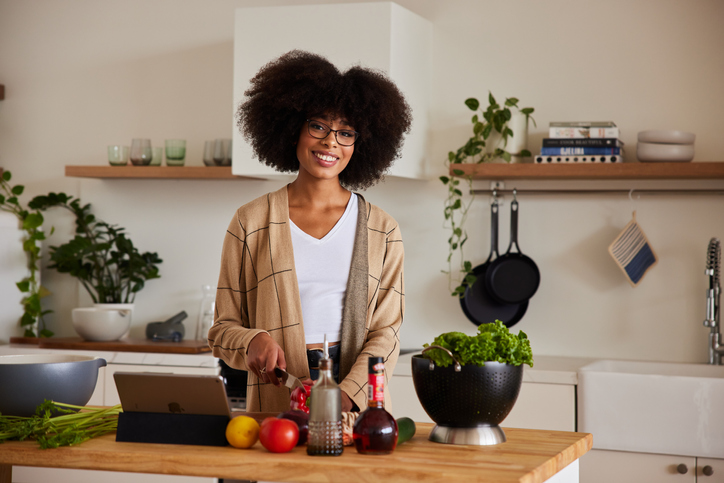 Smiling young woman preparing a healthy meal in her kitchen