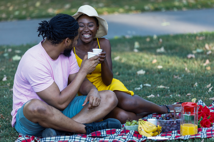 A Couple of African-American Ethnicity is Enjoying an Outdoors Picnic.
