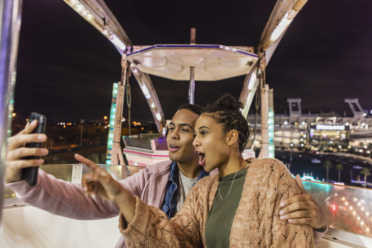 Young African-American couple riding ferris wheel