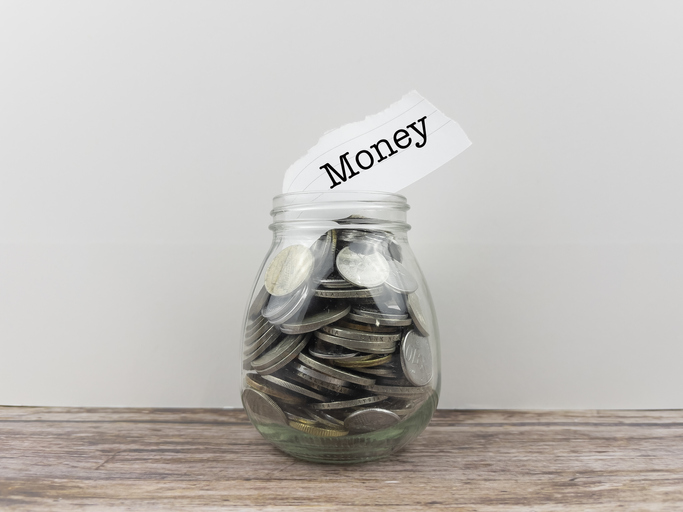 Money word with coins inside the jar. money for business investment finance and banking concept.