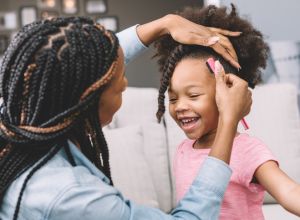 mother styling daughter's curly hair