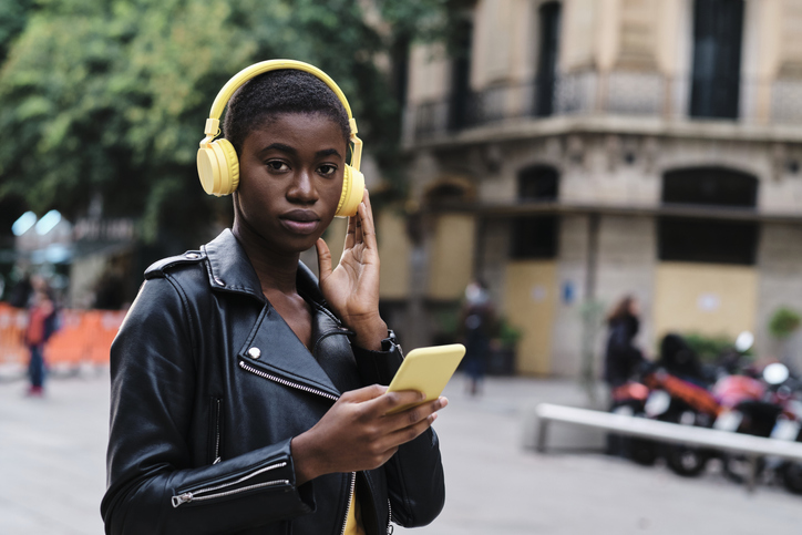 Woman listening music while standing in city