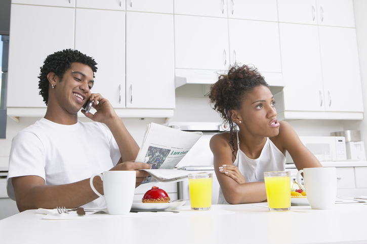 Frustrated African woman in kitchen with boyfriend