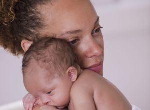 African American woman holding newborn baby
