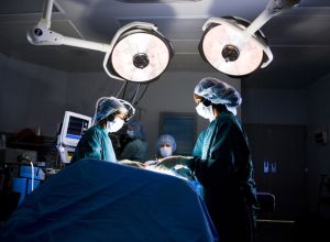 Female nurse and surgeon in scrubs during surgery