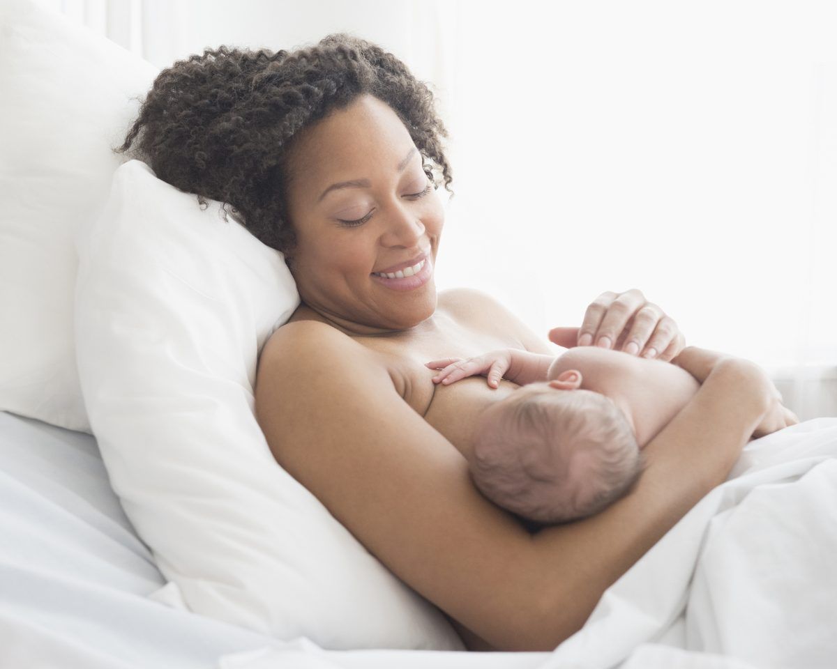 Mixed race mother nursing newborn baby