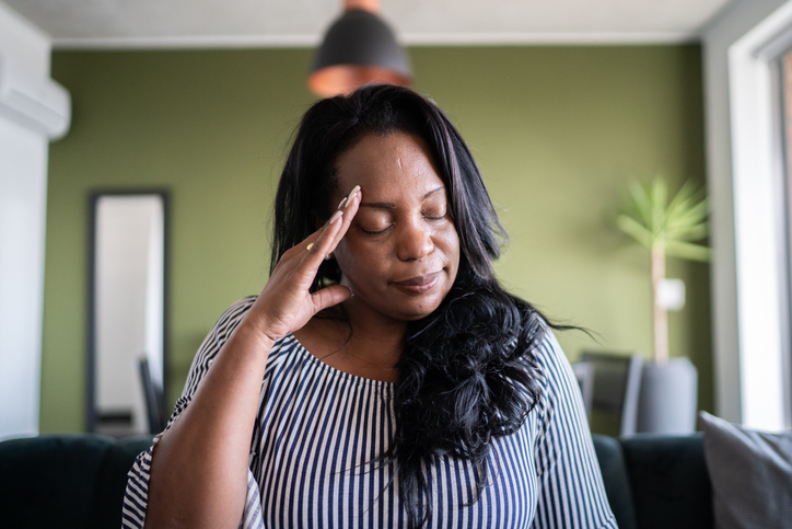 Mature woman with headache at home