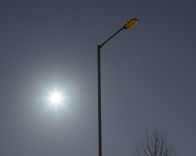Switched off urban streetlight in moonlight.