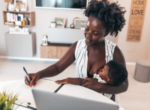 Business woman working at home and taking care of her two daughters