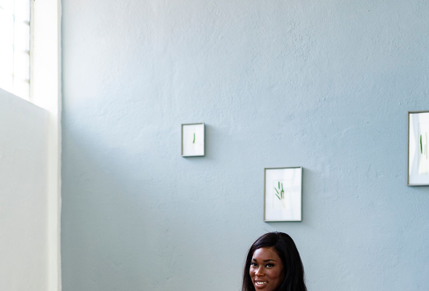 Happy pregnant young woman sitting on fitness ball at home