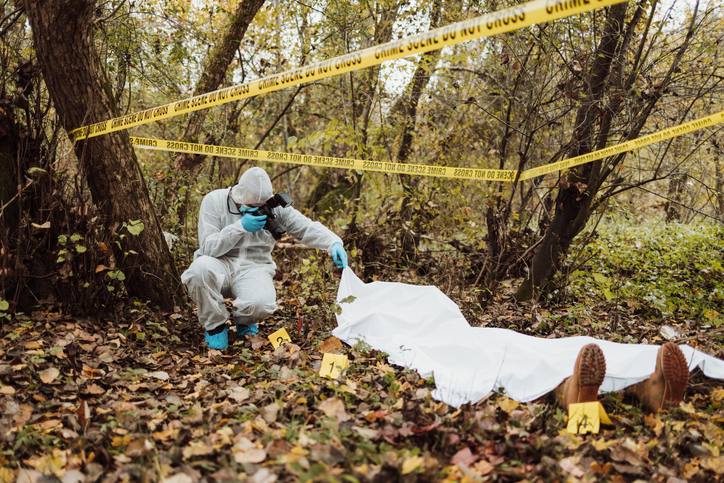 Group of people, crime scene investigation, police and forensics doing their jobs, there is a dead body in the forest.
