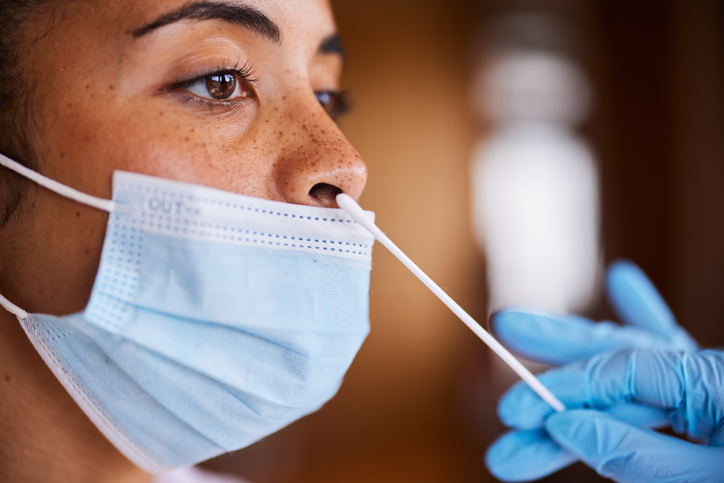 Woman in a mask getting a nasal swab for a covid test
