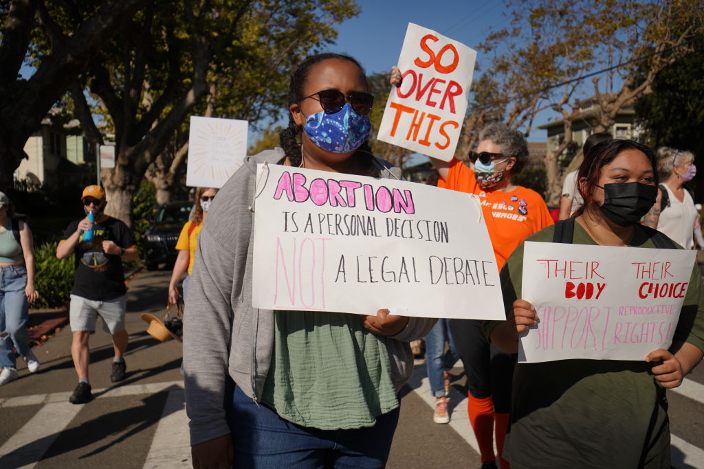 Protesters hold placards during the demonstration. Around...