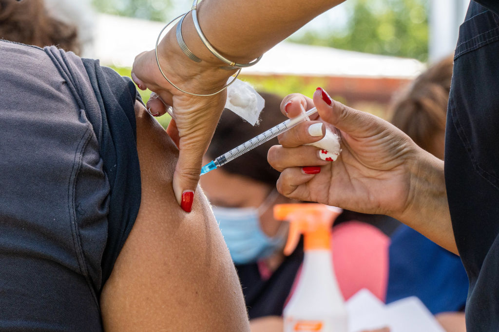 A health worker administers a Covid-19 booster jab to a...