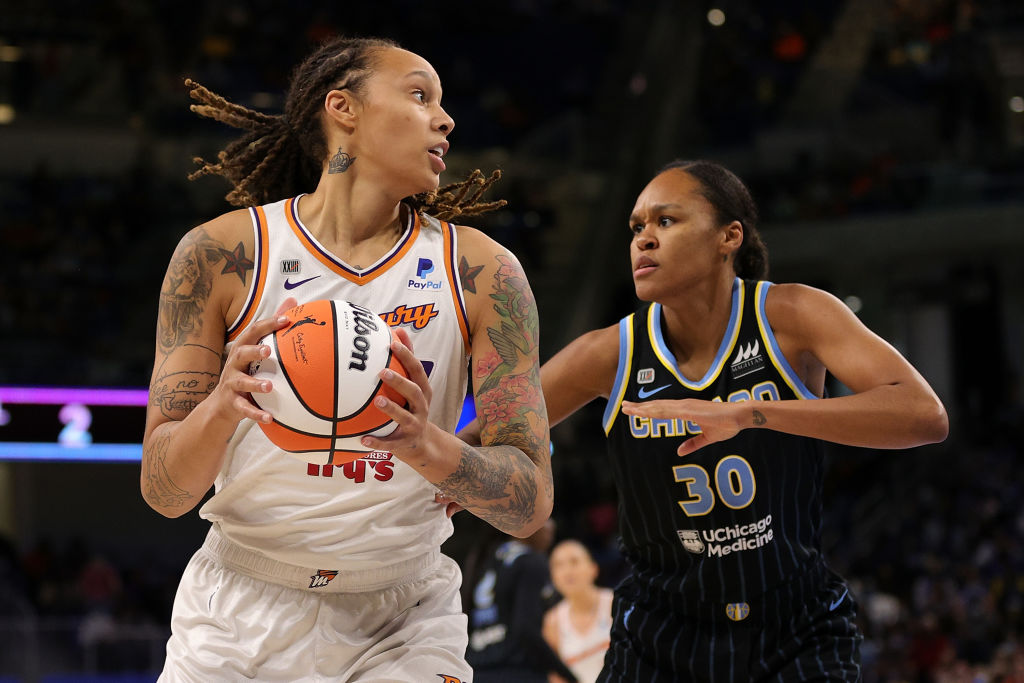 Britney Griner holds a basketball as she is efended by Azurá Stevens #30 of the Chicago Sky.