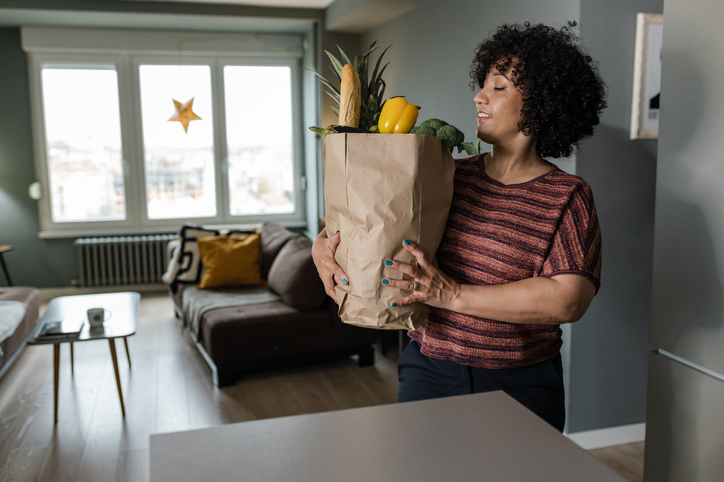 Woman holding a bag full of healthy groceries