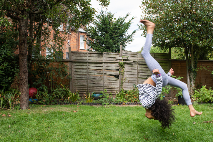 Young girl performing gymnastics in back garden