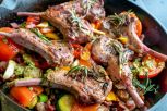 Cast Iron Skillet Filled with Gourmet Lamb Chops and a Vegetable Medley of Brussels Sprouts, Bell Pepper, Garlic, Leeks Tomato, Garlic and Pesto
