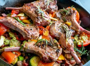 Cast Iron Skillet Filled with Gourmet Lamb Chops and a Vegetable Medley of Brussels Sprouts, Bell Pepper, Garlic, Leeks Tomato, Garlic and Pesto