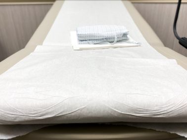 generic medical examination table & patient gown