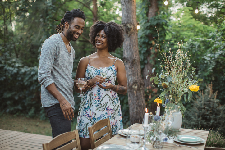 Couple arranging table for dinner in backyard