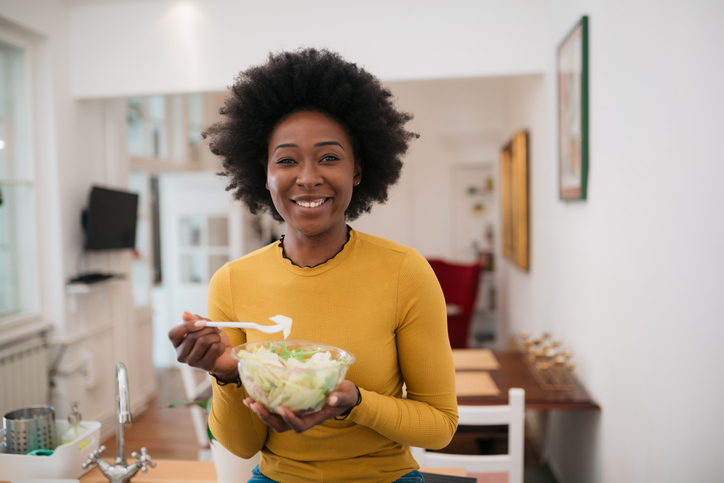 Portrait of a beautiful African American woman enjoying her food at home