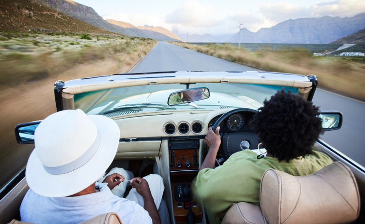 Mature couple driving in their convertible along a scenic country road