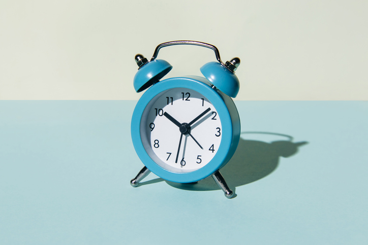 Alarm clock on a blue and beige background