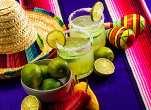 Happy Cinco de Mayo with two Margarita Glasses on a Colorful Mexican Blanket