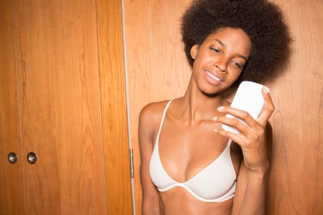 Woman in bra using cell phone