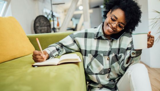 Portrait of African American woman enjoying coffee and writing her business plan