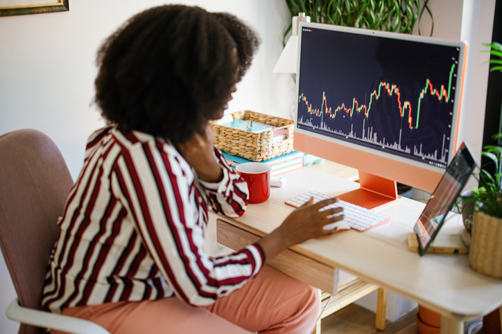 Young woman using cryptocurrency application on smartphone, computer and digital tablet