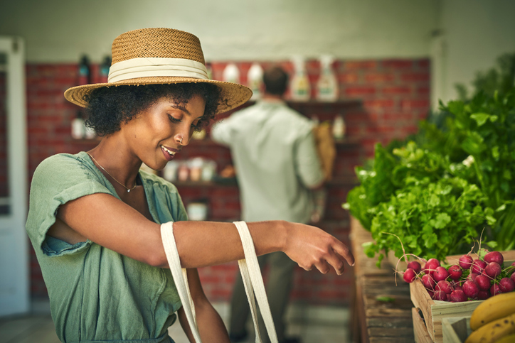 Shot of a young woman shopping for fresh produce at a farmer’s market