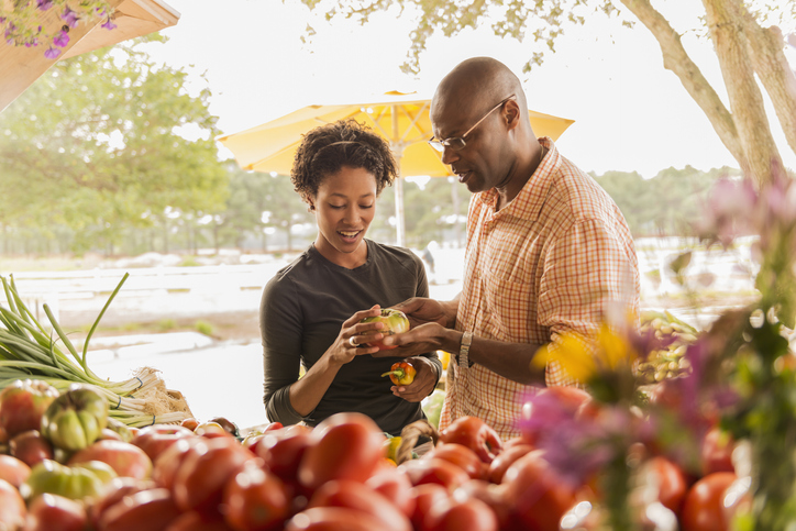 African American couple browsing produce in farmers market