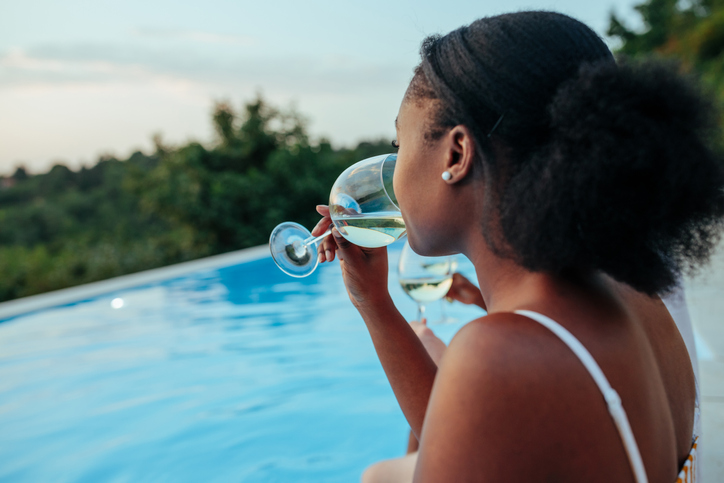 Portrait of black woman drinking wine from Black-owned wineries outdoors