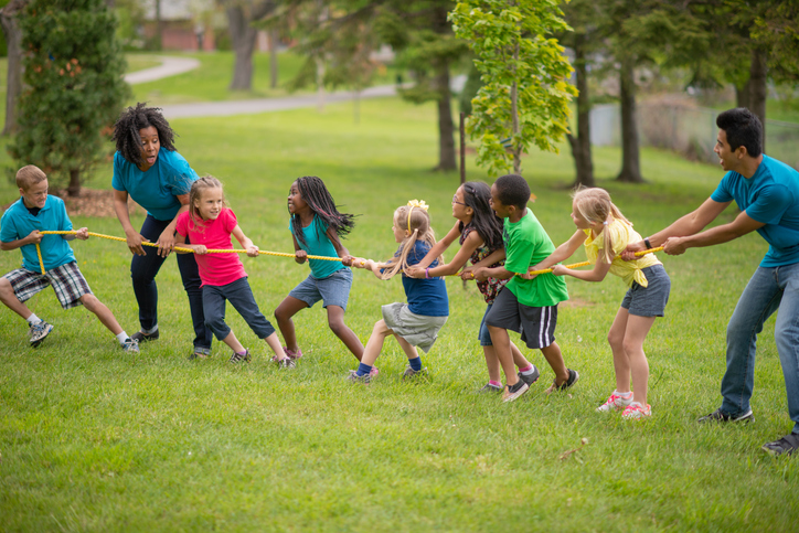 Camp Counsellors and Children Playing Tug of War at Summer Camp