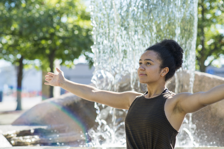 Young Woman Practicing Yoga by a Fountain