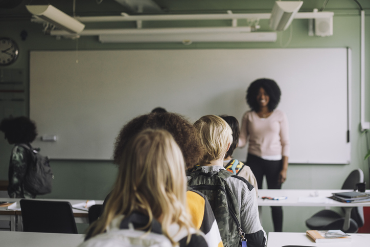 Multiracial students walking in queue while leaving classroom