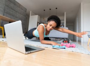 Woman training at home watching virtual workout classes