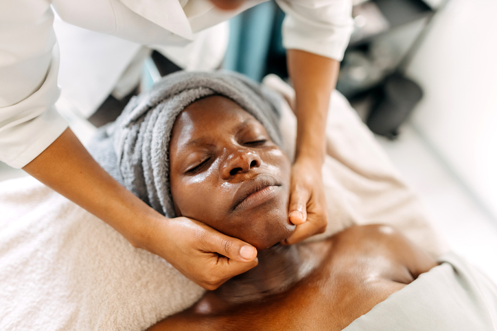 Woman enjoys a facial massage as one of weird spa treatments