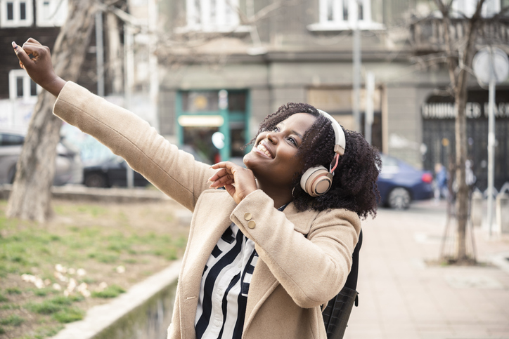 Afro girl enjoying her favorite music in the city