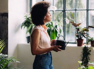 Mid Adult Mixed Race Woman taking care of her Houseplants