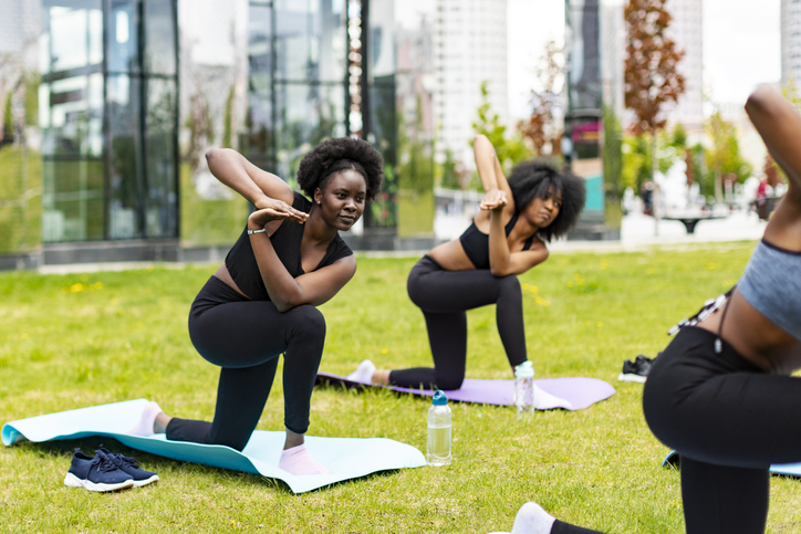 Young African Women Practicing Yoga In Public Park