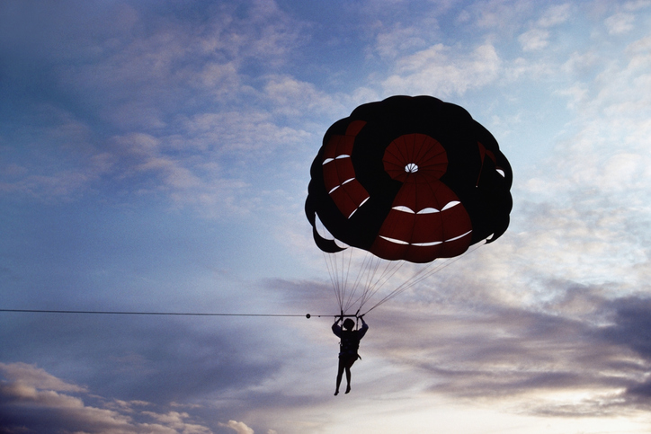 Silhouette of a person parasailing at sunset, Bahamas