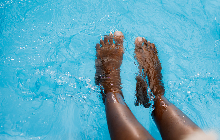 Close up of African American woman's legs in the pool.