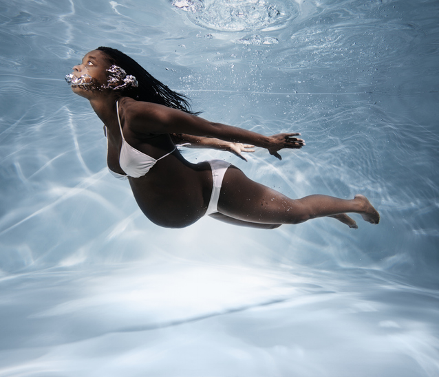 Pregnant woman swimming underwater