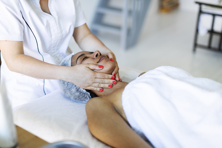 Cosmetologist making face massage at home