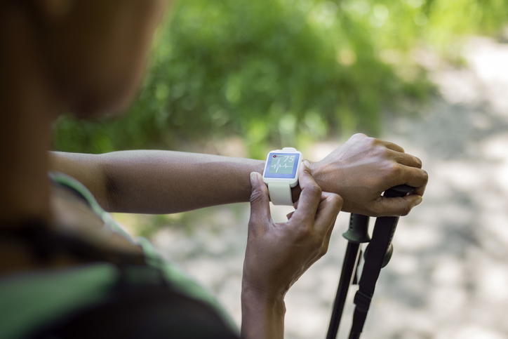 African-American Ethnicity woman checking a heartrate on smartwatch
